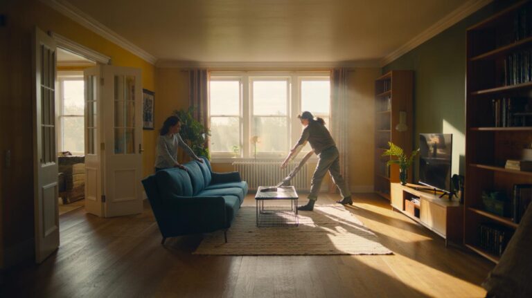 Illustration of a bright living room being rearranged to improve energy flow, with a floated sofa, clear walkways, and daylight streaming through unobstructed windows